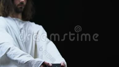 穿着长袍的耶稣，在镜头前展示圣经，<strong>信仰</strong>和<strong>信仰</strong>，黑暗的背景